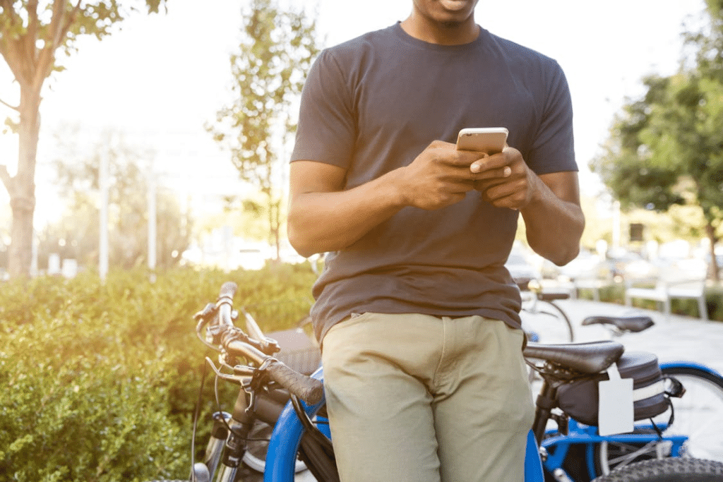Young man examining the Happy Slots promo code offer with his phone while on the go