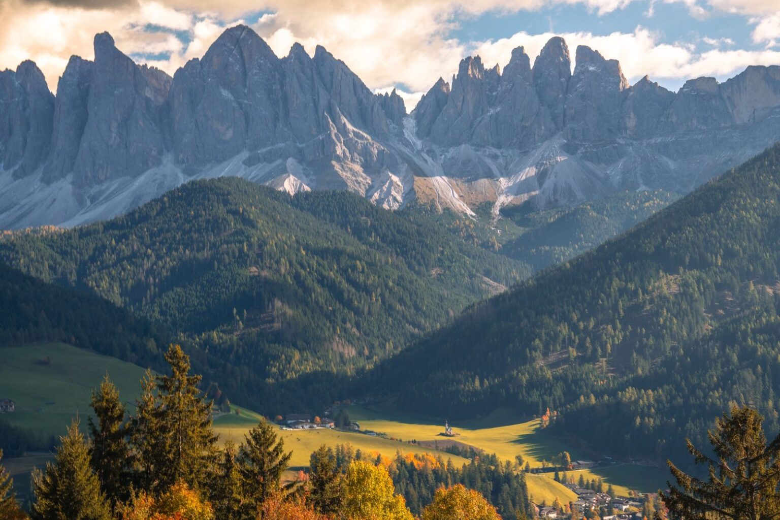 Mountain peaks above autumn trees, illustrating a quiet hotel stay near a ski area